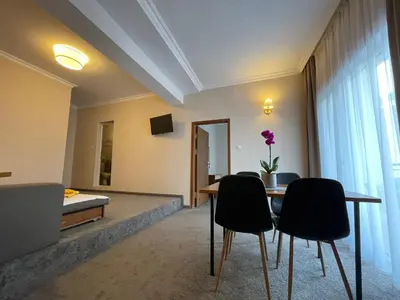 a room with a table and chairs and a bed at Alatoni Beach Hotel in Sozopol