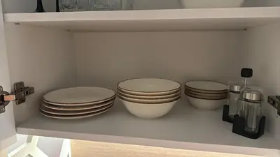 four plates and bowls sitting on a shelf at Sorrento Sole Mare Studio Appartment in Sveti Vlas