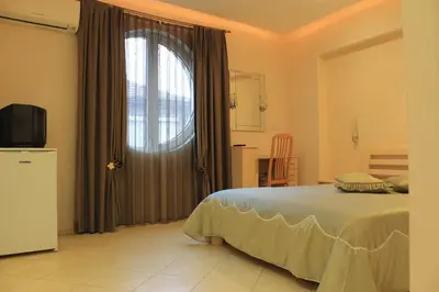 a bedroom with a bed and a large window at Stela Guest House in Tsarevo