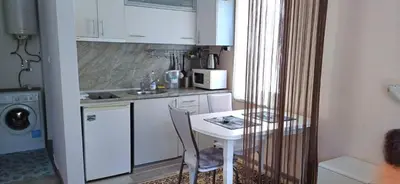 a small kitchen with a table and a table and chairs at Blu Bey Pomorie in Pomorie