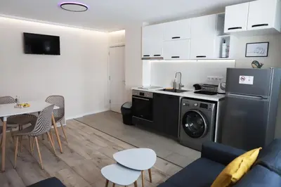 a kitchen with a washing machine and a table at Azur Holiday Burgas - self check-in in Burgas City