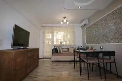 a living room with a television and a table and chairs at Relax apartment with parking in Varna City