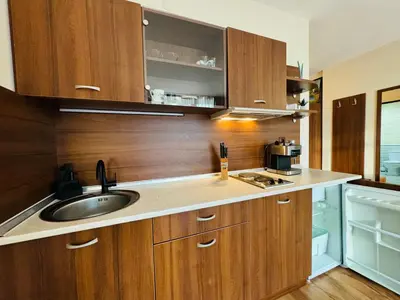 a kitchen with wooden cabinets and a sink at GRENADA 322C Studio Sunny Beach in Sunny Beach