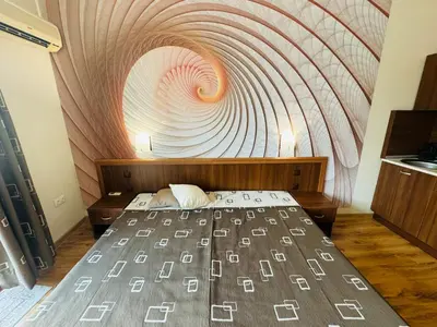 a bedroom with a bed with a swirl painting on the wall at GRENADA 322C Studio Sunny Beach in Sunny Beach