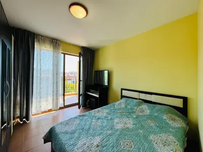 a bedroom with a bed and a television and a window at AMADEUS I B31 Apartment Sunny Beach in Sunny Beach