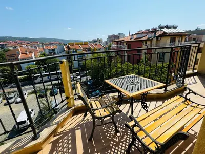 a balcony with two benches and a table on a balcony at AMADEUS I B31 Apartment Sunny Beach in Sunny Beach