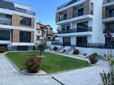 an apartment building with a lawn in front of it at Студио Морски дни-топ локация в Созопол in Sozopol