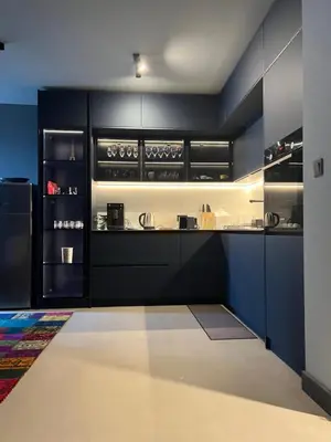 a kitchen with black cabinets and a refrigerator at Apartament Panorama in Pomorie