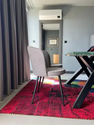 a chair sitting on a rug next to a table at Apartament Panorama in Pomorie