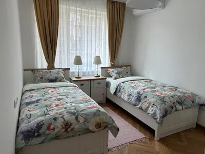 a bedroom with two beds and a window at Romantic City Central Apartment in Varna City