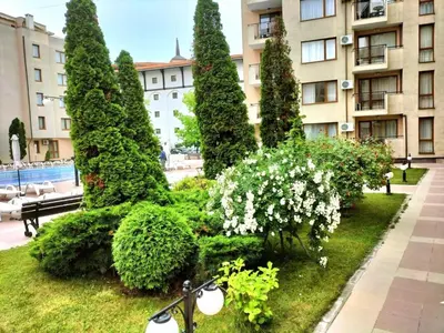 a bike parked in a garden in front of a building at Sunny Beach Victoria Penthouse in Sunny Beach