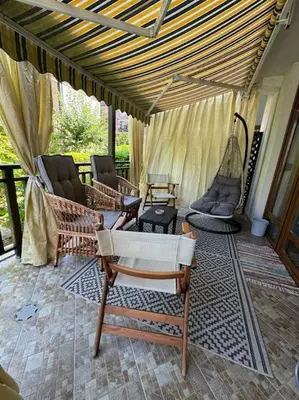 a porch with chairs and hammocks on a patio at Niko's Apartment in Sozopol