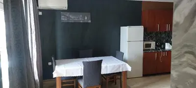 a small kitchen with a table and a refrigerator at Marina bay in Sveti Vlas