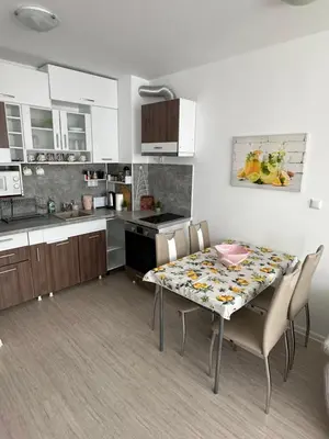 a kitchen with a table and chairs in a kitchen at Apartament Diana in Pomorie