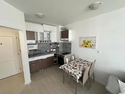 a kitchen with a table and chairs in a room at Apartament Diana in Pomorie