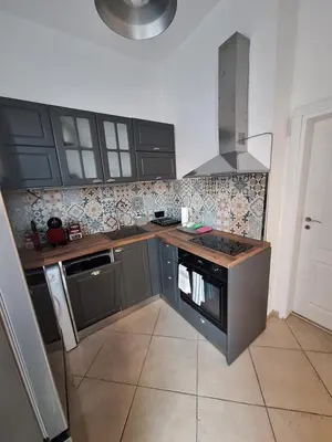 a kitchen with black cabinets and a stove top oven at Apartment Black Sea Center 1 in Varna City