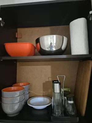 a shelf with bowls and other kitchen utensils at Делукс Апарт Вергиеви in Burgas City