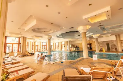 a pool in a hotel with two people sitting in the water at Emerald Beach Resort & Spa in Ravda