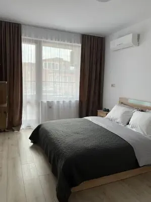 a bedroom with a large bed and a window at New and stylish apartment Tuthon in Pomorie