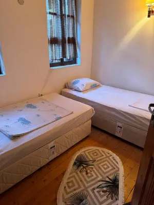 two beds in a room with a rug at Вила Мила in Tsarevo