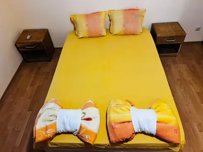 a large yellow bed with two pillows on it at Къща за гости ФОРЕВЪР in Banya