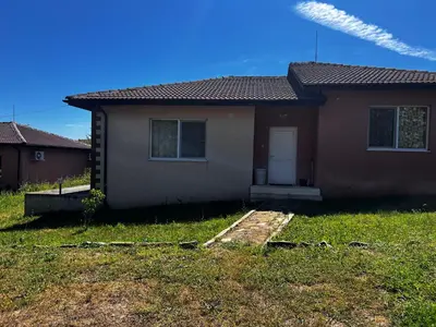 a brown house with a white door in the yard at Къща за гости ФОРЕВЪР in Banya