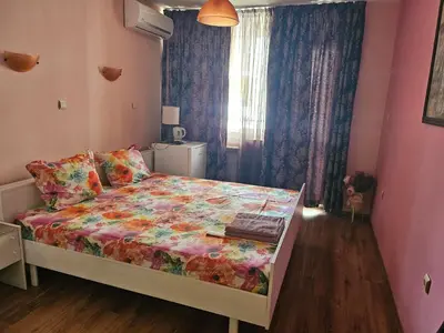 a bedroom with a bed with a colorful comforter at Стая за гости на Бургас 1 in Burgas City