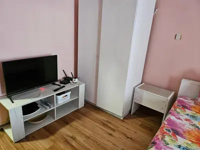a living room with a flat screen tv on a stand at Стая за гости на Бургас 1 in Burgas City