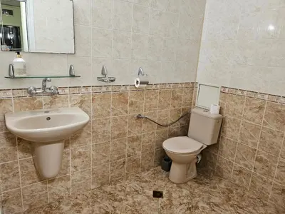 a bathroom with a sink and a toilet and a mirror at Стая за гости на Бургас 1 in Burgas City
