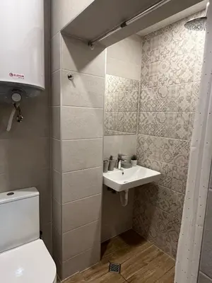 a small bathroom with a toilet and a sink at Handmade - central studio in Varna City