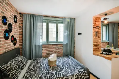 a bedroom with a bed and a brick wall at Handmade - central studio in Varna City
