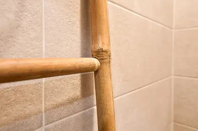 a wooden pole on a tiled wall in a bathroom at Handmade - central studio in Varna City