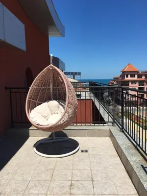 a rattan chair sitting on the balcony of a building at The Red Lozenets in Lozenets