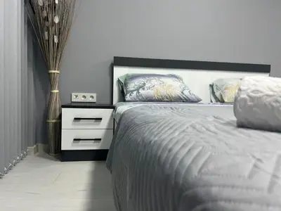 a bedroom with a large bed and a night stand at NJ bedroom in Varna City