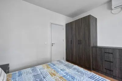 a bedroom with a bed and a wooden cabinet at Private 1-BD Apartment with Balcony in Sveti Vlas by Flat Mаnаger in Sveti Vlas