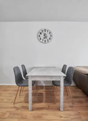 a table with chairs and a clock on a wall at Private 1-BD Apartment with Balcony in Sveti Vlas by Flat Mаnаger in Sveti Vlas