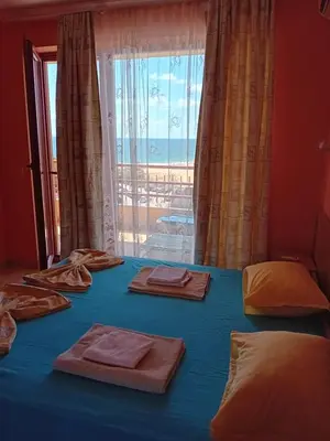 a room with a blue bed with a large window at Златна Дюна - до южния плаж на Несебър in Nesebar