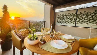 a wooden table with plates and glasses on a balcony at Luxury sea view, 5star Barcelo on Beach in Sunny Beach