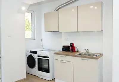 a white kitchen with a sink and a dishwasher at Bright 2-Bedroom Apartment Near Varna City Center by Flat Mаnаger in Varna City