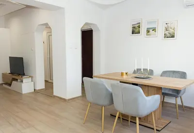 a dining room with a wooden table and chairs at Bright 2-Bedroom Apartment Near Varna City Center by Flat Mаnаger in Varna City