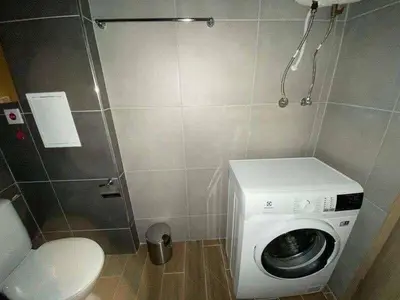 a bathroom with a washing machine and a toilet at Luxury Apartments in Cascadas Family Resort Sunny Beach in Sunny Beach