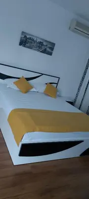 a bedroom with a white bed with yellow pillows at Stephanovy Guest House in Sozopol