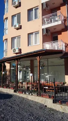 a building with tables and chairs in front of it at Stephanovy Guest House in Sozopol