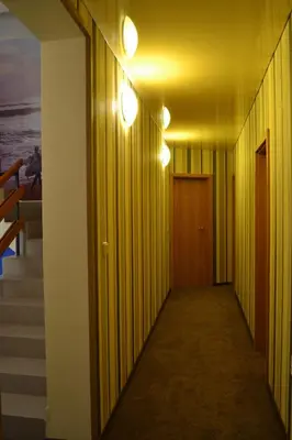 a hallway with two lights on the wall and stairs at Stella Del Mare Guest House in Kiten