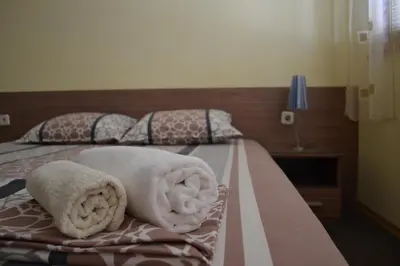 a bedroom with two beds with towels on them at Stella Del Mare Guest House in Kiten