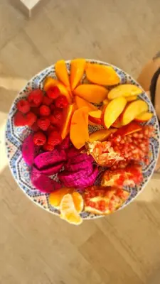 a plate of fruit and vegetables on a table at Garden of Eden - Sea View studio in Sveti Vlas