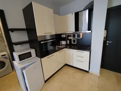 a kitchen with white cabinets and a microwave at Garden of Eden - Sea View studio in Sveti Vlas