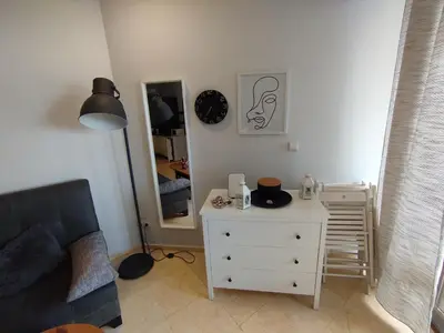 a living room with a couch and a dresser and a mirror at Garden of Eden - Sea View studio in Sveti Vlas