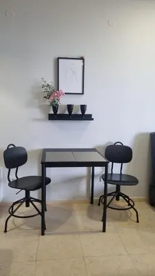 a table with two chairs and a picture on a wall at Garden of Eden - Sea View studio in Sveti Vlas