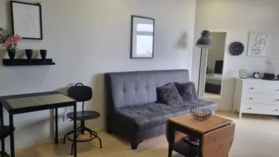 a living room with a couch and a table at Garden of Eden - Sea View studio in Sveti Vlas
